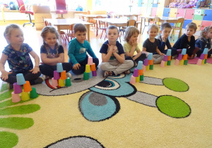 Dzieci układają wieżę z kubeczków według wzoru.